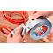 Hands taping red cable with grey tape. Tape roll with "tesa" print.