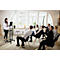 A woman presents in front of a group. A man raises his hand. Others listen attentively.