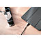 A black power strip with a white charger plugged in. A black cable connects to a gray tablet.