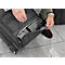 Une personne ouvre la poche extérieure d'une valise noire. Un compartiment gris est visible à l'intérieur.