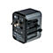 Schwarzer Universal-Reiseadapter mit ausfahrbaren Steckern für USA, UK und EU vor weißem Hintergrund.