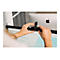 Person befestigt Webcam an Monitor. Im Hintergrund ist ein Apple Monitor mit Apfel-Logo zu sehen.
