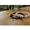 Ein schwarzes und ein weißes USB-C-Kabel liegen auf einem Holztisch.