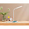 Bureau met lamp, telefoon en bloemen. De witte lamp brandt. Op het bureau liggen een telefoon, een klok en een notitieblok.