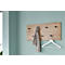 Holzgarderobe an hellblauer Wand. Ein grauer Schal hängt an der Garderobe. Darunter ein weißer Kleiderbügel.