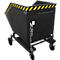 Black tilting container on wheels with yellow and black warning stripes.