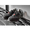 Black work shoes with laces, resting on a metal shoe rack, leaning against a wall.