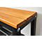 Close-up of a wooden bench with black metal legs. The seat consists of light brown wooden boards. A silver screw is located at the corner.