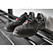 Black safety shoes with red details are on a black shelf.
