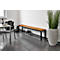 Wooden bench with black frame and shelf. Next to it, a large plant in a decorative pot.
