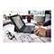 Ein Mann arbeitet an einem Tablet mit Tastatur, das auf einem Tisch mit Bauplänen liegt. Auf dem Bildschirm ist eine E-Mail-Übersicht zu sehen.
