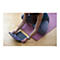Eine Person in Yoga-Kleidung sitzt mit verschränkten Beinen auf einer Yogamatte und bedient ein Tablet mit Tastatur.