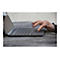 Une main tape sur un pavé tactile d'ordinateur portable. Le doigt avec du vernis à ongles foncé touche la surface.
