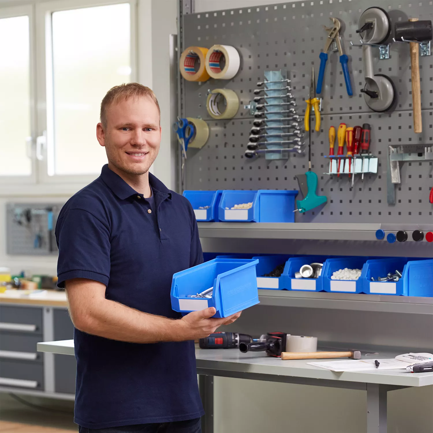 Een man staat voor een werkbank met een LF-bak in zijn handen