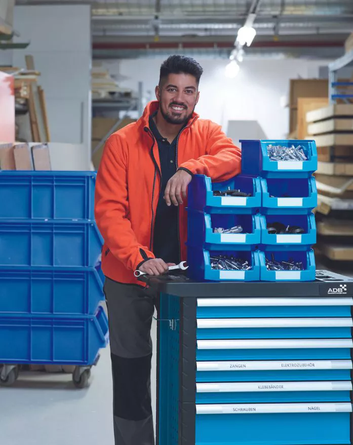 Un employé dans un entrepôt regarde la caméra en souriant