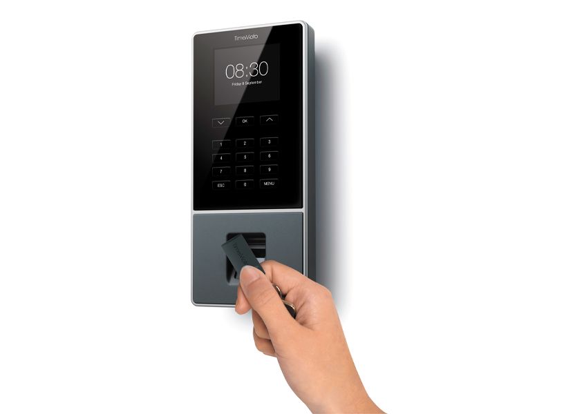 Ein RFID-Chip wird vor den Terminal eines Zeiterfassungssystems gehalten