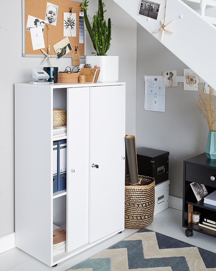 Kleine kamer in het thuiskantoor ingericht met schuifdeurkast en prikbord