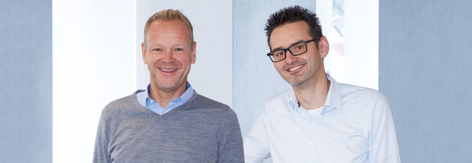Andreas Reuter und Andreas Dietz stehen nebeneinander und lächeln.