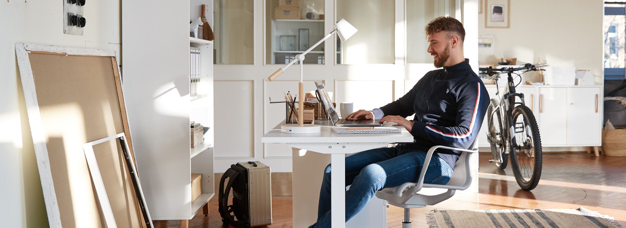 Arbeit im Homeoffice mit höhenverstellbarem Schreibtisch und Bürostuhl.
