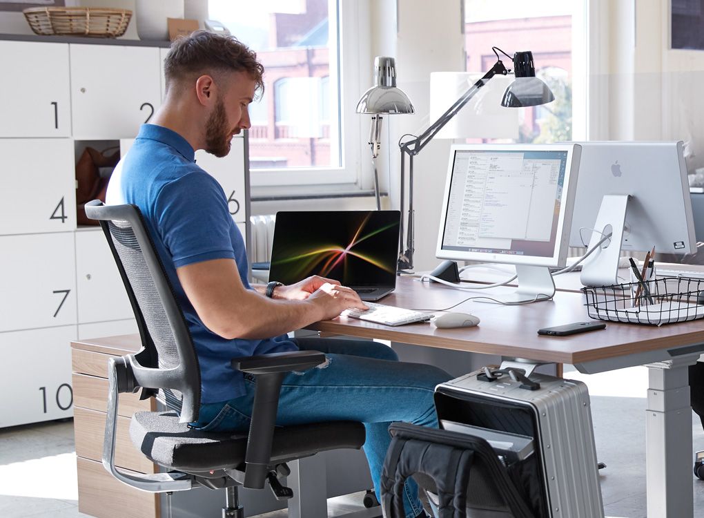 Mitarbeiter arbeitet im Desksharing-Büro mit flexibler Ausstattung.