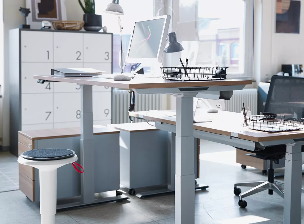 Ergonomische Hocker und höhenverstellbare Schreibtische im Büro
