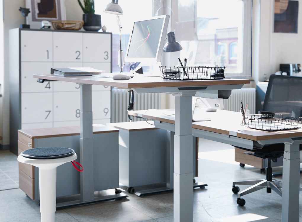 Tabouret ergonomique et bureaux réglables en hauteur au bureau.