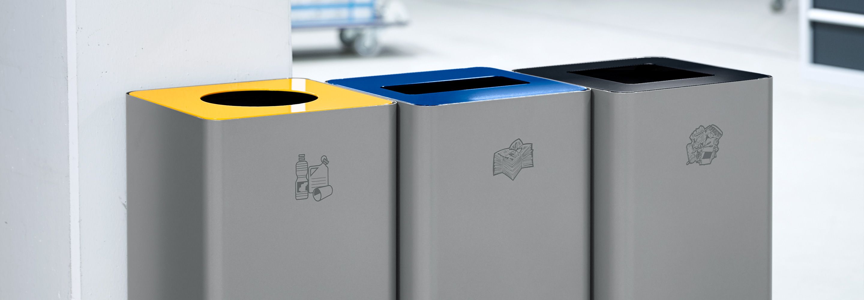 Drei Abfallbehälter  - einer für Plastikmüll, einer für Altpapier und einer für Restmüll.