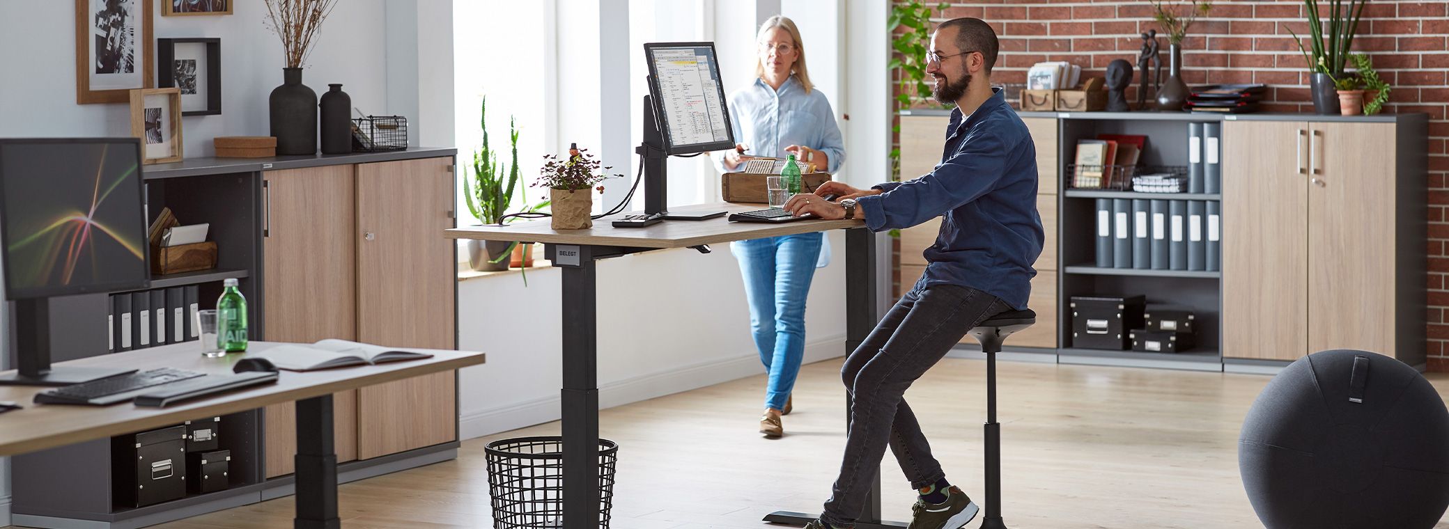 Twee collega's werken samen in het kantoor met ergonomisch meubilair
