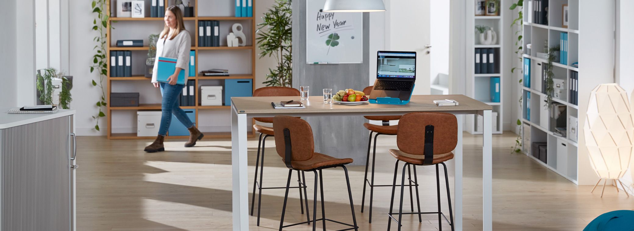 Moderner Meetingbereich mit Stehtisch, Notebook und Hockern