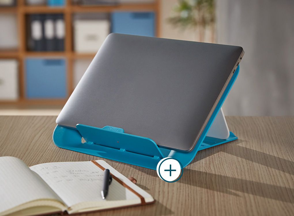 Konferenztisch mit Notizbuch, Laptop und Notebookständer