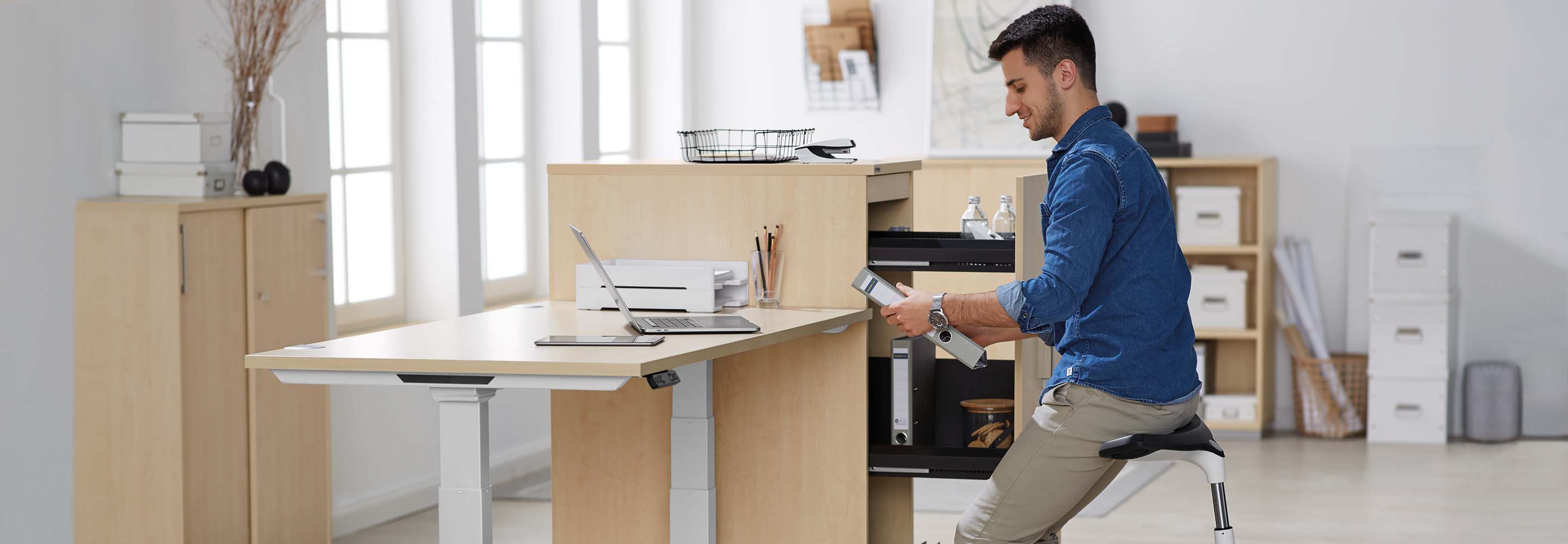 Une personne assise sur un tabouret à son poste de travail