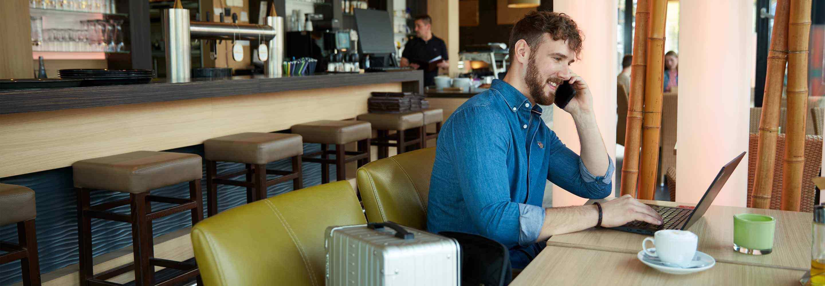 Eine Person, die im Café am Laptop arbeitet