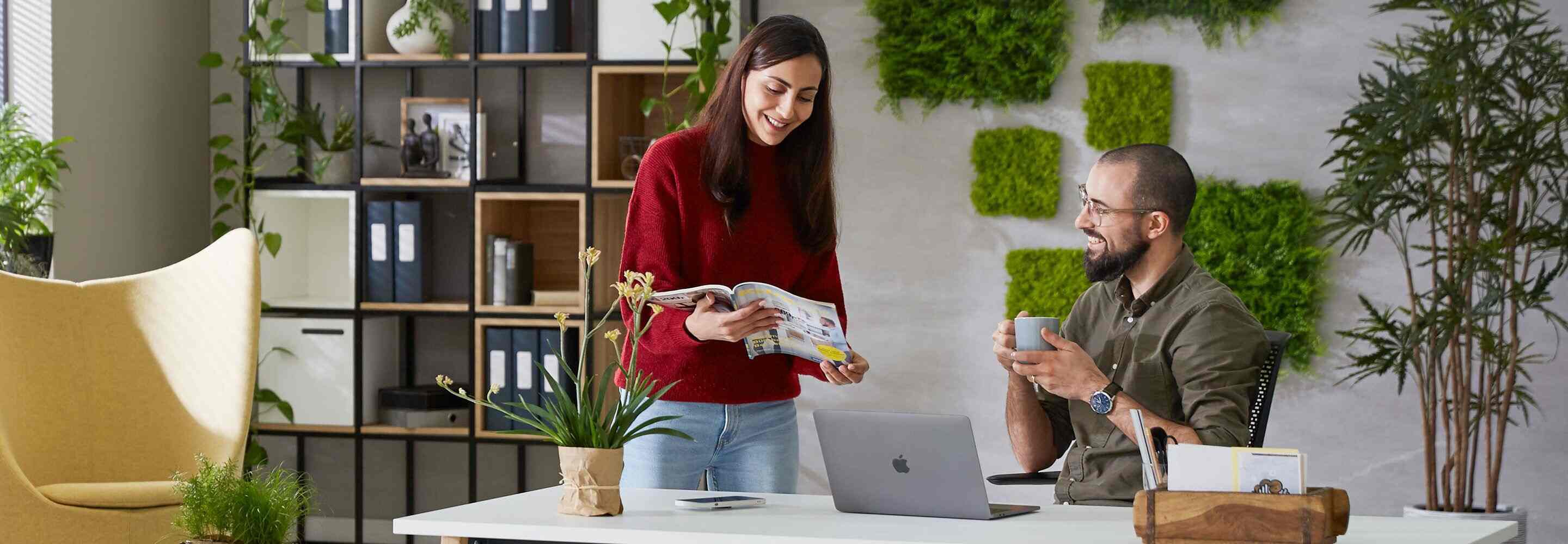 Une personne assise et une personne debout au bureau 