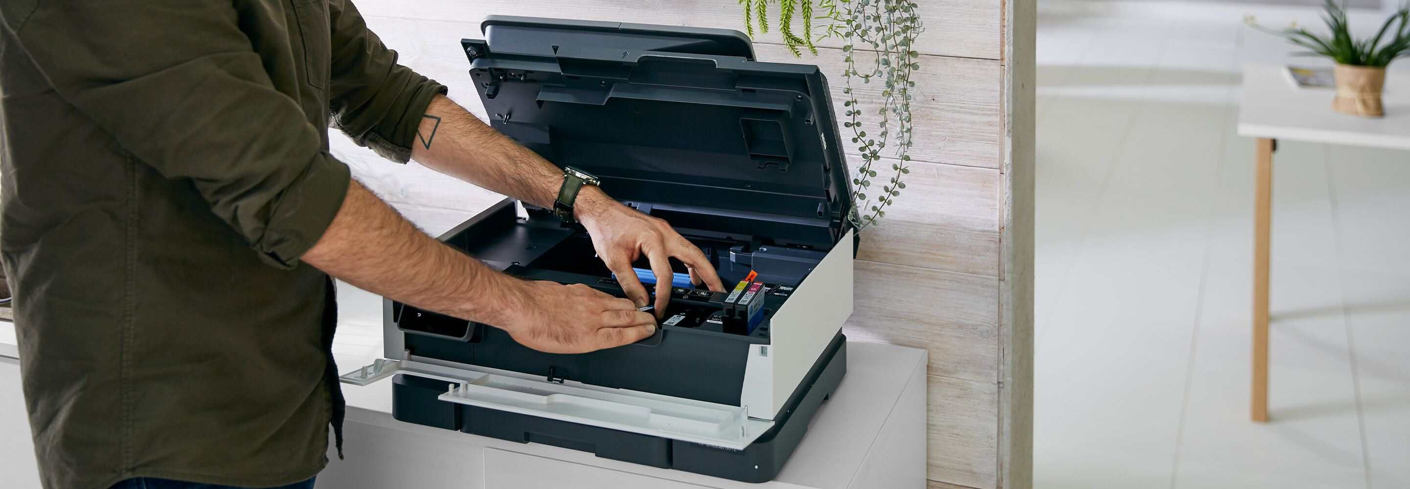 Een man werkt aan een printer.