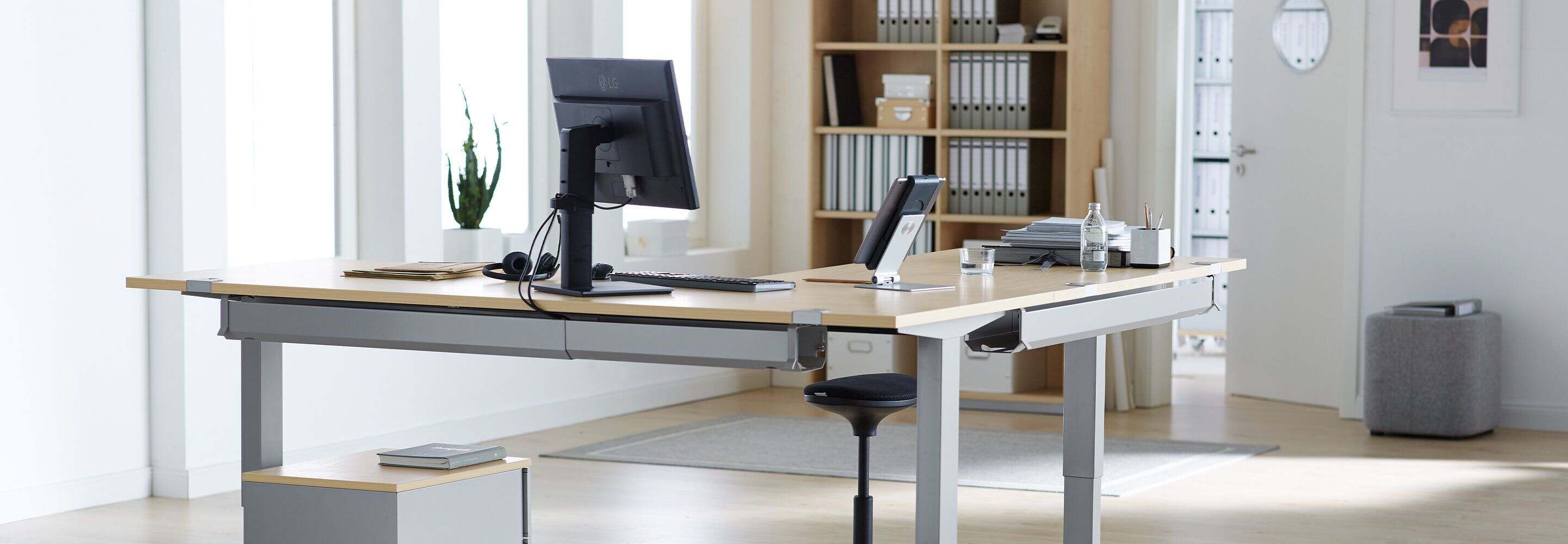 Personne debout à un bureau réglable en hauteur
