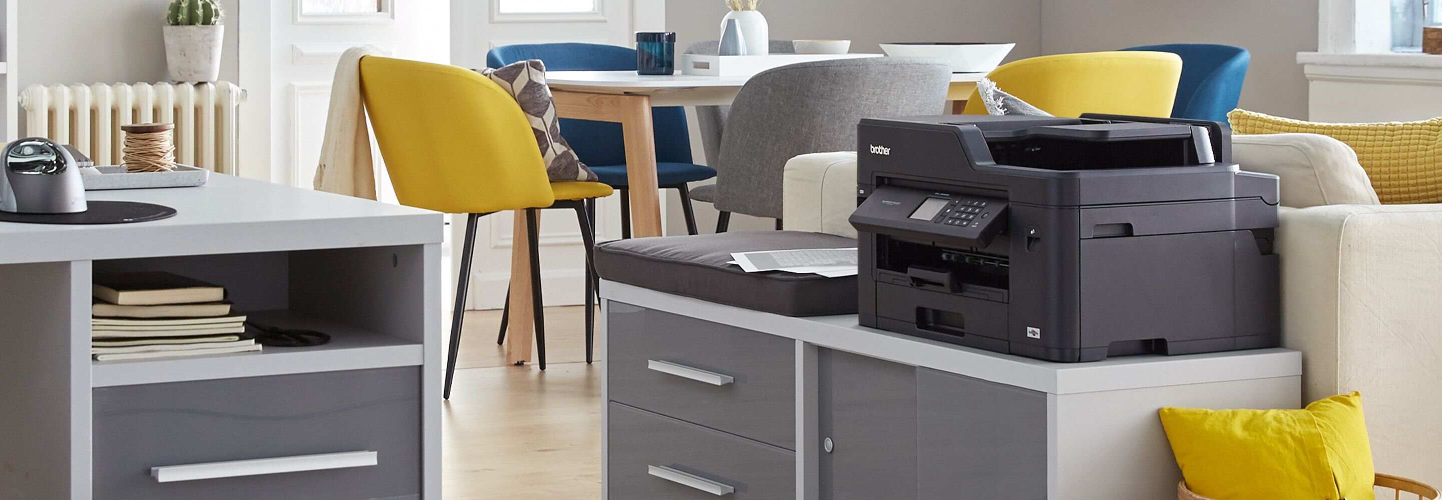 Een printer staat in een kleurrijk ingericht kantoor.