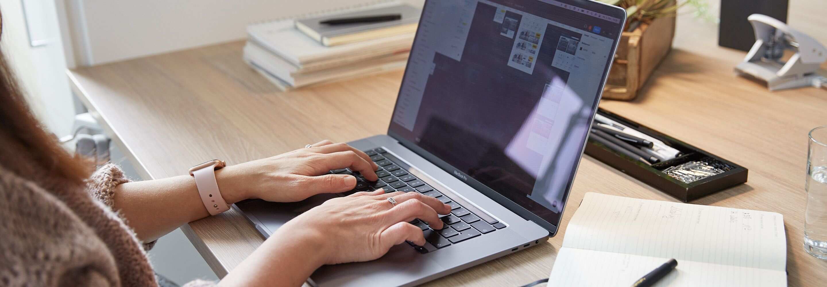 Nahaufnahme einer Frau, die an einem Laptop arbeitet.
