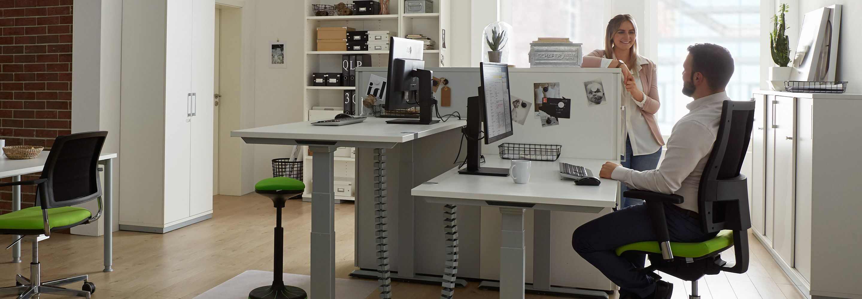 Eine Frau und ein Mann unterhalten sich an ihrem Arbeitsplatz im Büro während ihrer Pause.