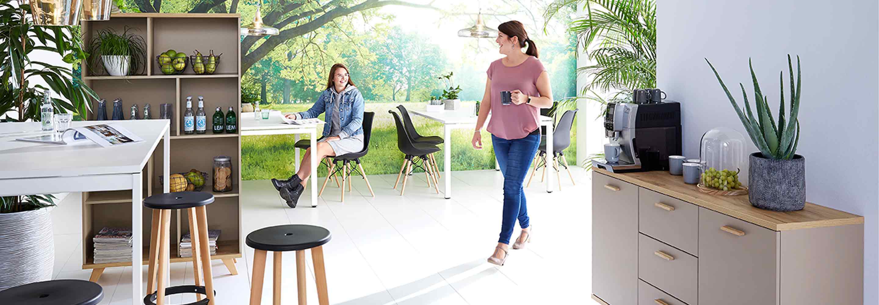 Twee vrouwen zijn in een pauzeruimte, de planken zijn gevuld met drank en voedsel. 