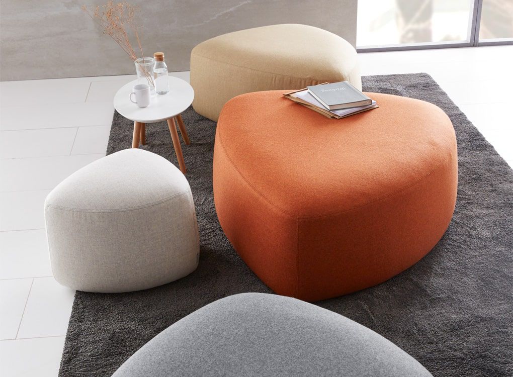 Lounge-Hocker in organischen Formen mit Beistelltisch und Deko-Accessoires