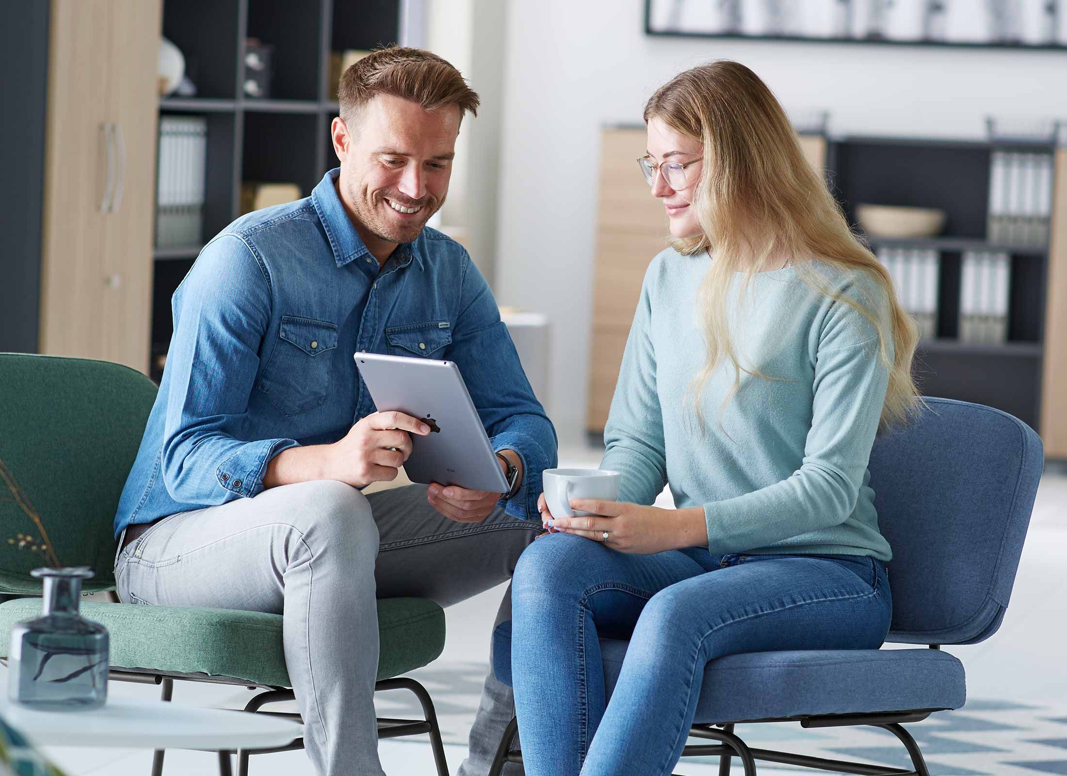 Ein Mann und eine Frau, die sich im Besprechungsraum gegenübersitzen