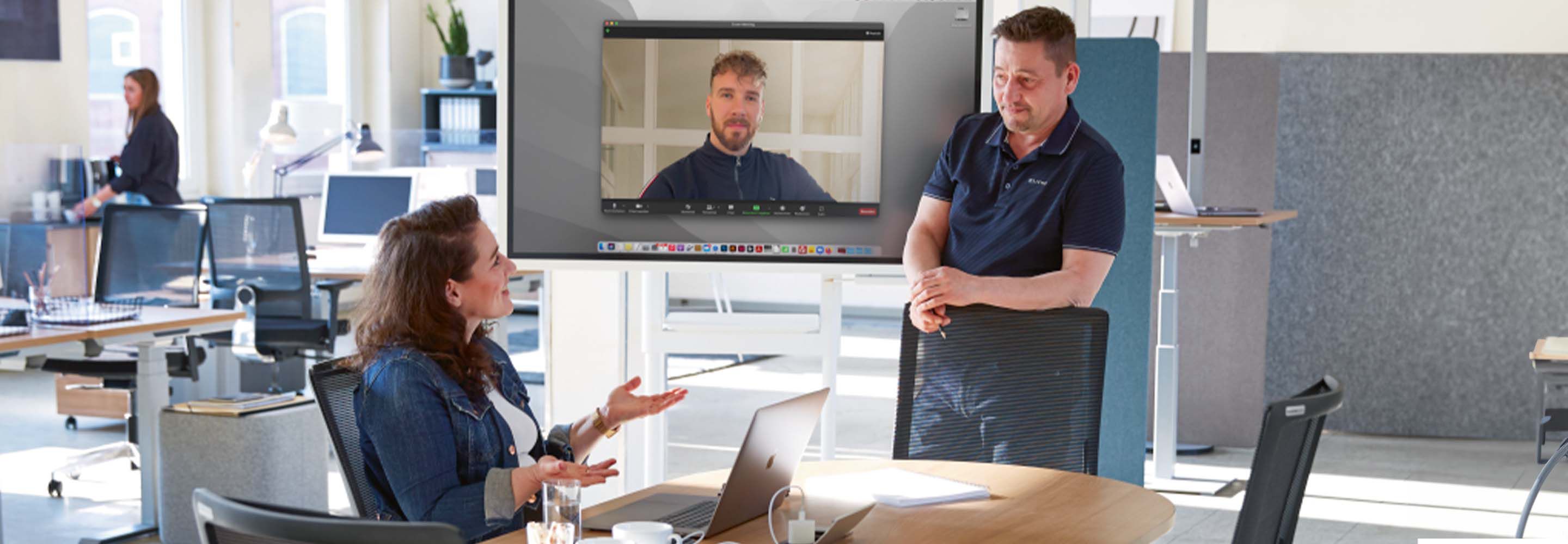 Drei Personen befinden sich in einem Workshop und halten gemeinsam eine Diskussion.