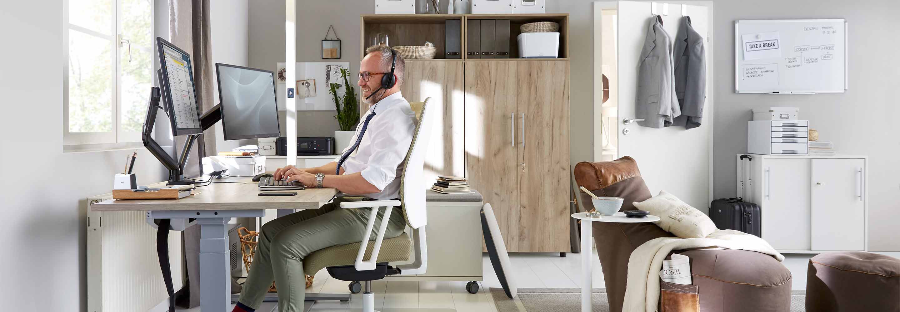 Een man zit aan zijn bureau en werkt vanuit huis.