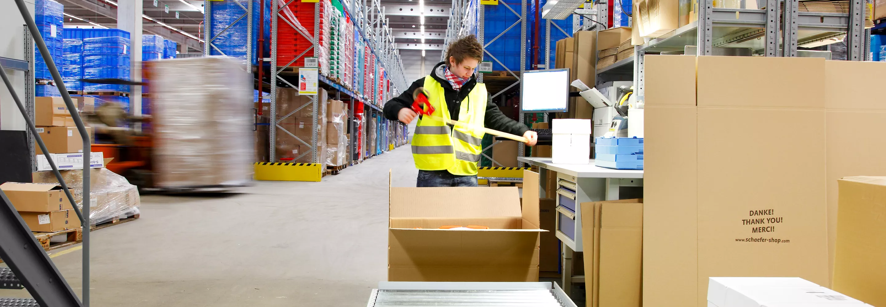Am Packtisch wird ein Paket sicher verpackt