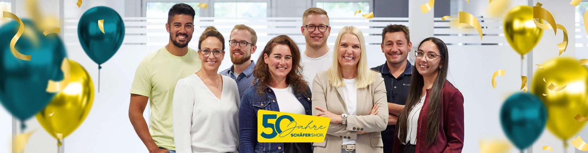 Drei Kollegen unterhalten sich in einem modernen Büro und lachen.