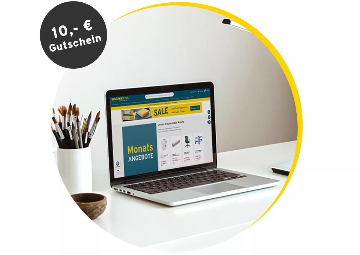 Laptop auf Schreibtisch mit geöffneter Webseite und 10-Euro-Gutschein-Hinweis oben links