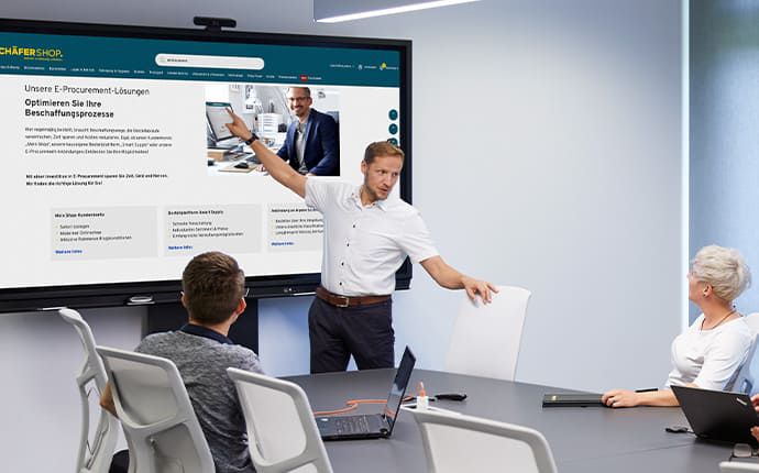 Team stellt E Procurement Lösung auf interaktivem Touchscreen im Konferenzraum vor
