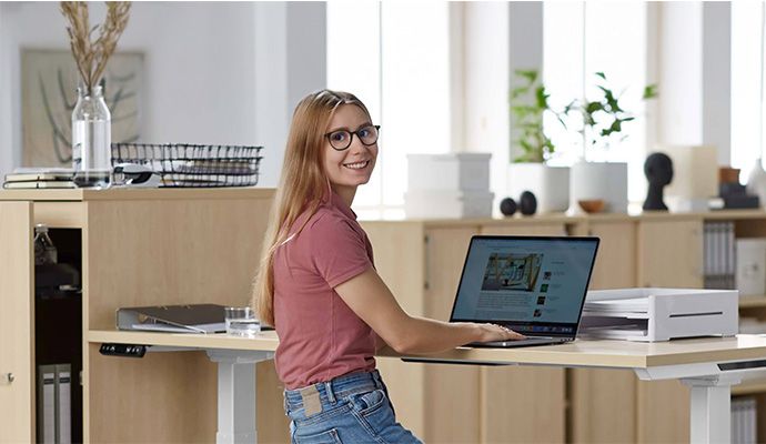 Eine am Schreibtisch sitzende Frau, die am Laptop arbeitet