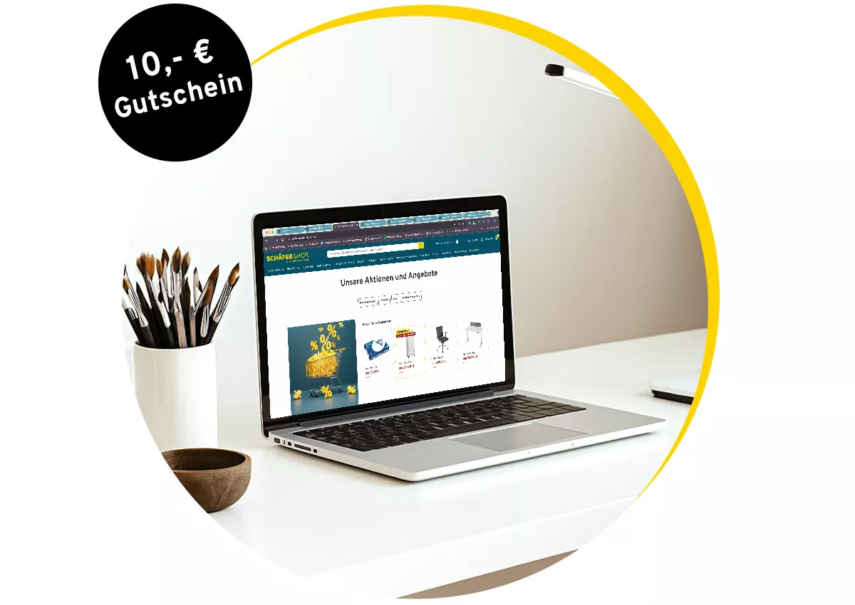 Laptop auf Schreibtisch mit geöffneter Webseite und 10-Euro-Gutschein-Hinweis oben links