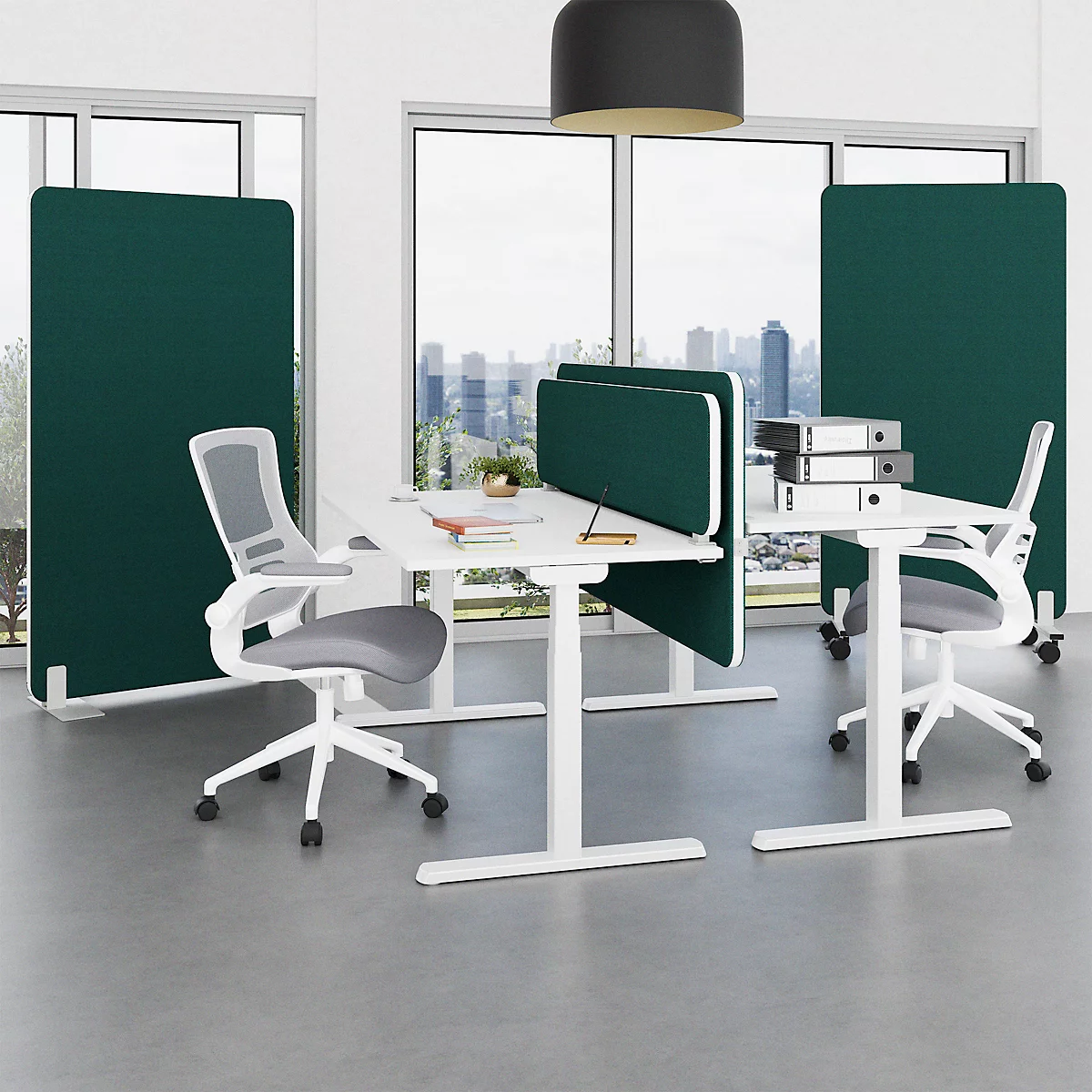 Office setup with desks, chairs, and green partitions in front of a window with a city view. Light fixture on the ceiling.